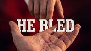 Two hands reach toward each other, encapsulating a moment of connection and compassion, with the poignant message "He Bled" symbolizing sacrifice and empathy.
