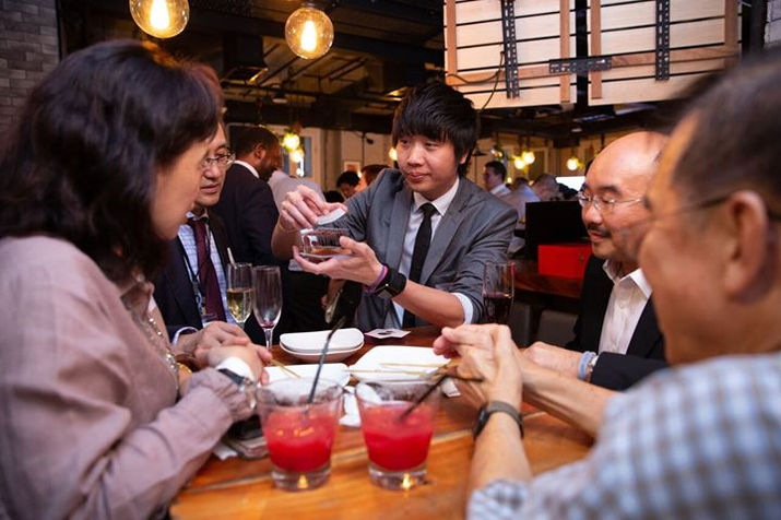 Magician performing close-up magic trick for guests at a Singapore restaurant