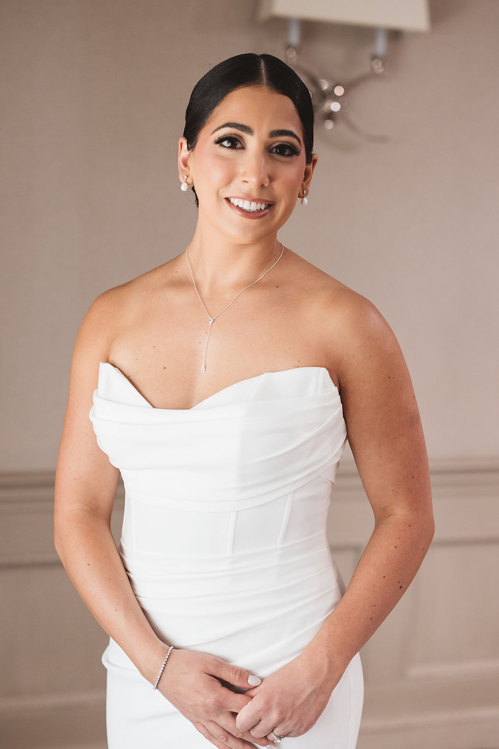 Bride smiles after getting dressed and ready in gown and accessories for her wedding day. Photographed at The Madison Hotel in Morristown, NJ by wedding photographer Madison Neumann Photography.