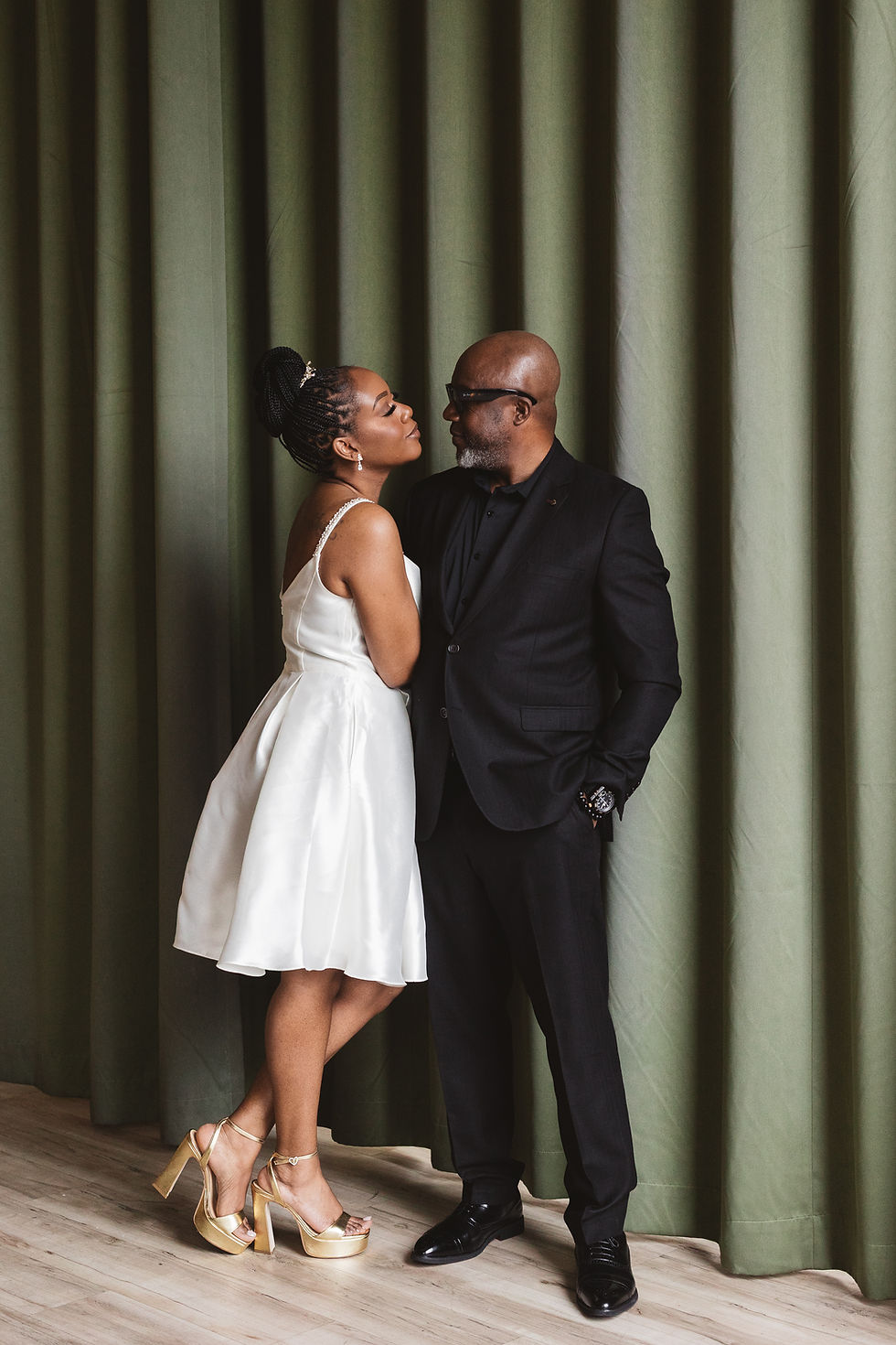Future bride and groom embrace for engagement portrait in front of green curtain wall in a bar. Engagement session at Lark in Bala Cynwyd, PA, photographed by South Jersey, Philadelphia based wedding photographer Madison Neumann Photography.