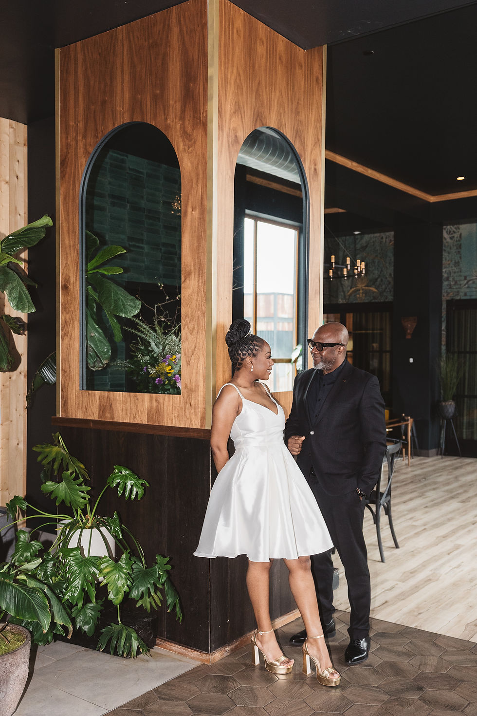 Bar with green walls and plants. Newly engaged fiancée's smile happily together in the bar. Engagement session at Lark in Bala Cynwyd, PA, photographed by South Jersey, Philadelphia based wedding photographer Madison Neumann Photography.