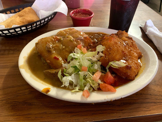 A delectable plate of green chile sopapilla from La Cosina in Raton, served with fresh lettuce, tomatoes, and a side of salsa.