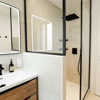 Salle de bain moderne avec douche à l’italienne et robinetterie noire mate