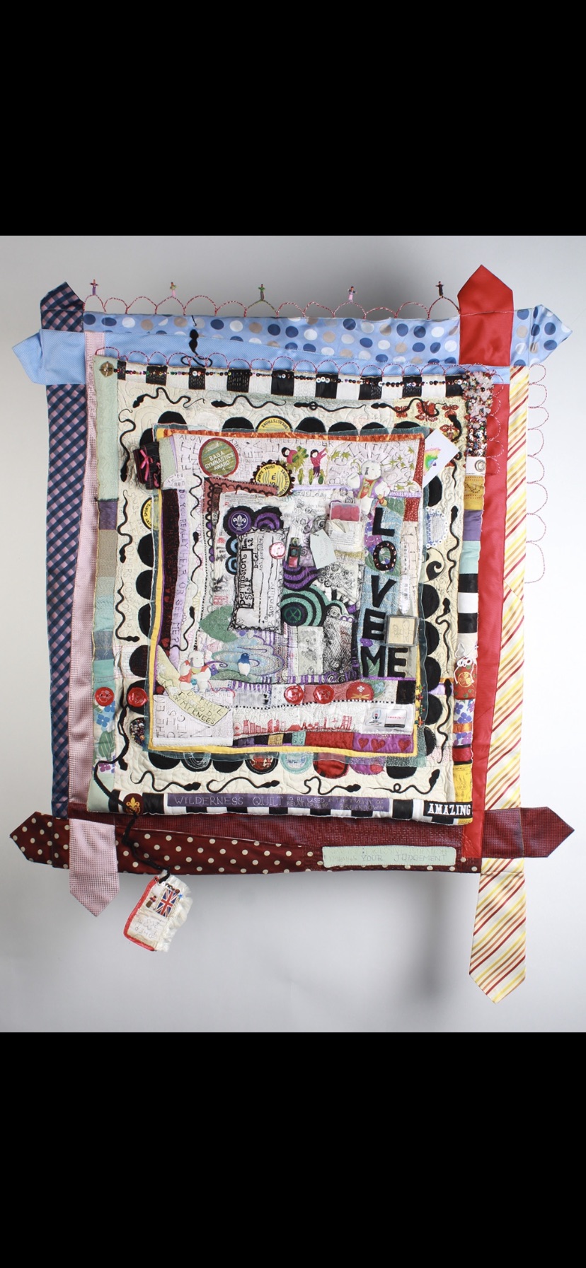 Full view of Wilderness Quilt showing layered reused materials, stitched thoughts and its irregular outer shape.