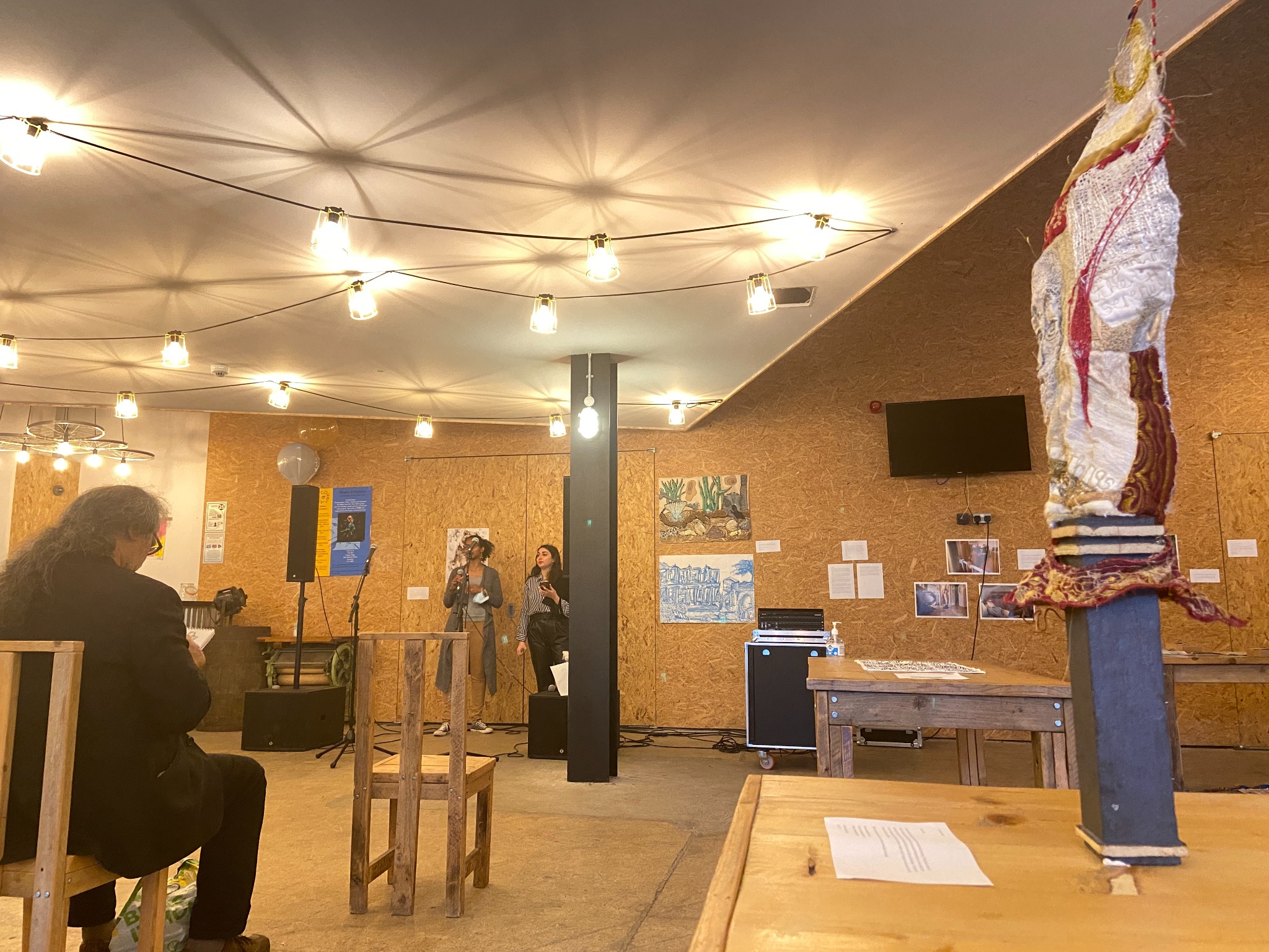 The Risers opening at The BOX in Coventry, with Amanda Haran's Book of Kells textile sculpture visible beside the poetry performance.