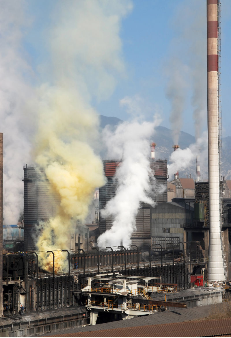 Plumes of sulpher dioxide and another gas being discharged by a large factory