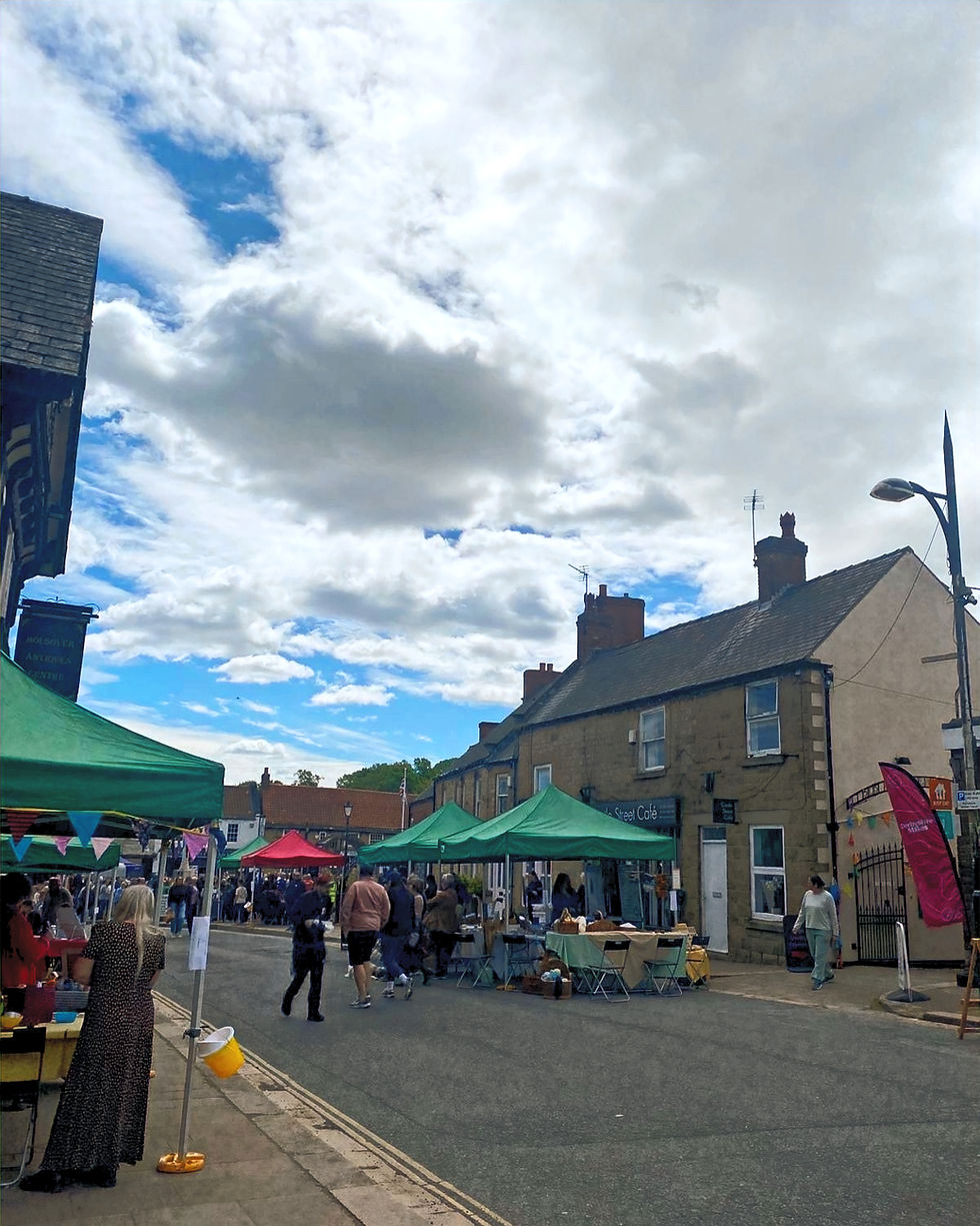 Closed streets in Bolsover during Derbyshire Makes with market stalls, artists and visitors gathered beneath dramatic skies in Derbyshire.
