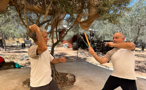 תלמידים בוגרים מתרגלים התמודדות מול התקפות סכין בעזרת מקל