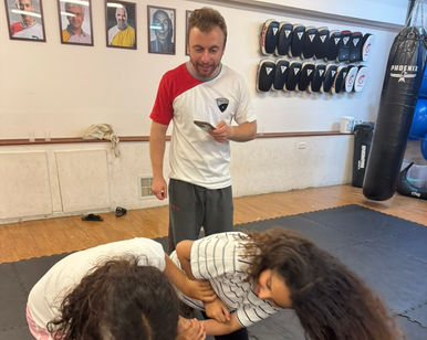 שתי ילדות מתאמנות באמנויות לחימה עם מאמן בהרצליה