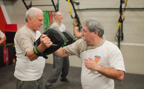 תלמידים מתרגלים אגרופי ווינג-צון על לאפות מצד לצד