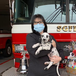 Lori celebrating with local fire department dalmatian after receiving corporate support for the pup's training from Invisible Fence and Pet Valu
