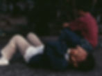 Person lying on ground, hands covering face; street photography in Intramuros, Manila.