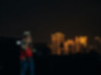 Man in an overpass overlooking the LED outlined buildings of the Rockwell District in Makati, during New Year's Eve.