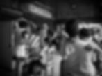 Child peeking from mother's arms in a busy Manila street.