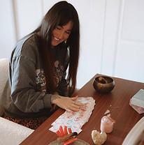 Pauline, guide holistique, souriante dans son cabinet, mains posées sur cartes oracles.