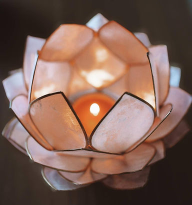 Photo d'un photophore en forme d'un lotus rose, avec bougie lumineuse.