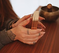 Mains tatouées de Pauline 22h22 qui tiennent des cartes oracles, pour pratiquer un accompagnement thérapeutique.
