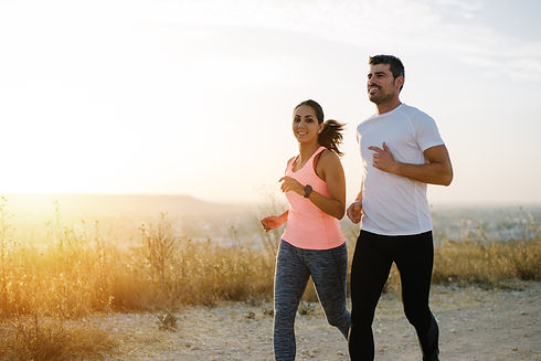 Two athletes running at sunset