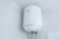 White electric water heater boiler on wall in the bathroom