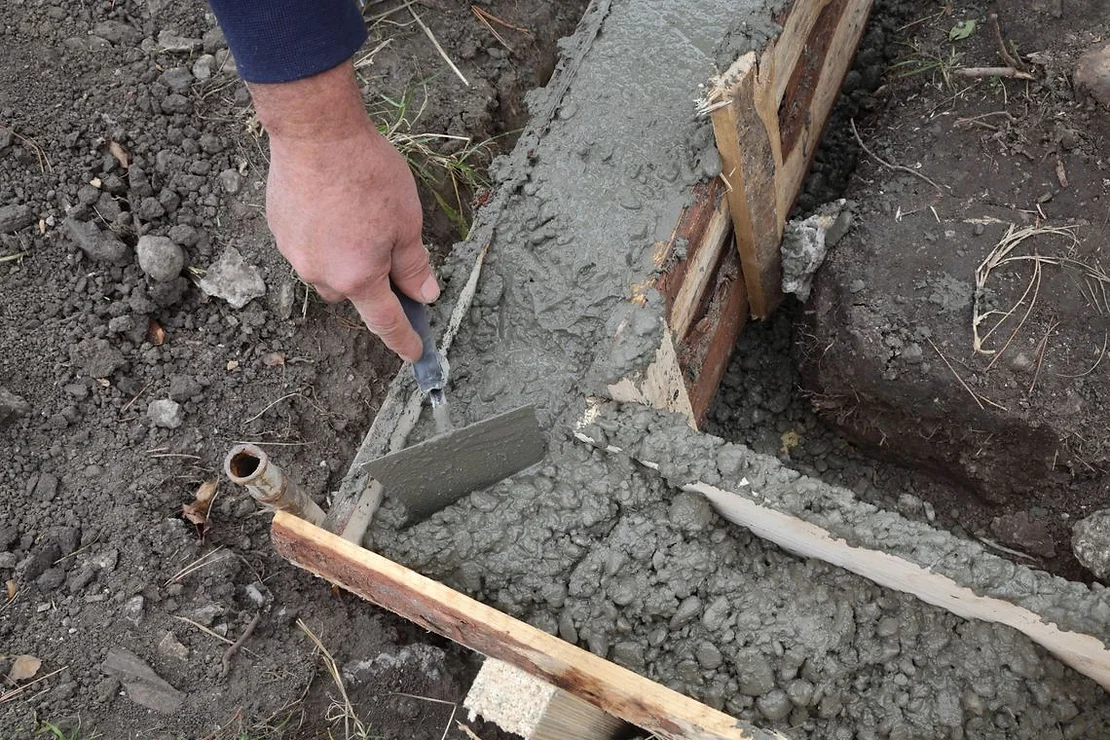 Worker applying concrete on a base