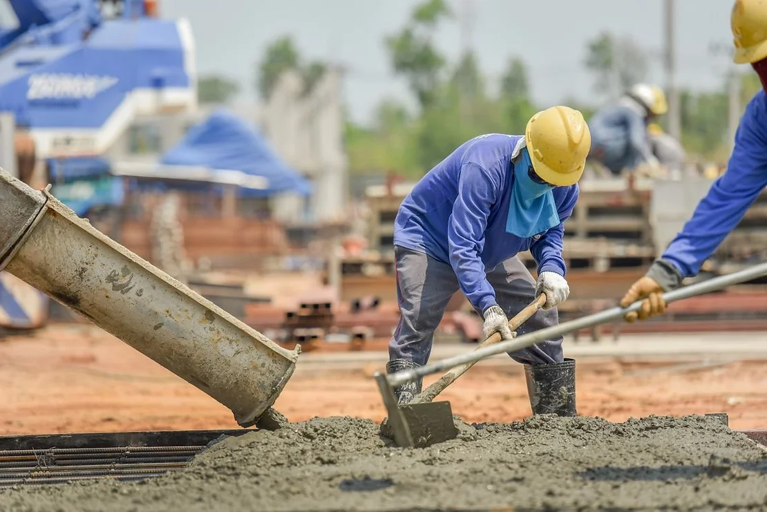 Workers laying concrete on a base