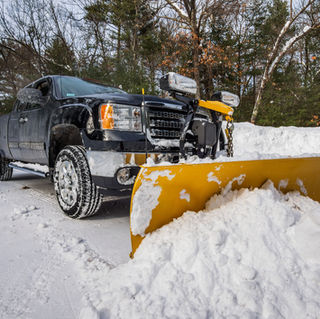 Pickup truck plowing snow