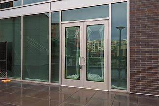View of front doors for a business still under construction and locked with a padlock key