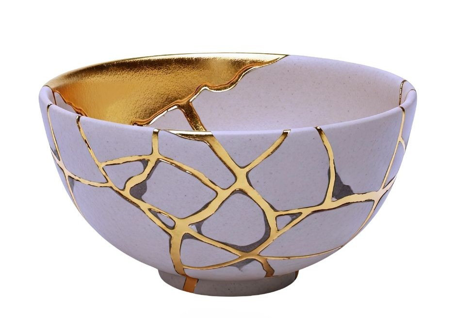 Decorative white ceramic bowl with gold crackle pattern and metallic interior on a plain white background.