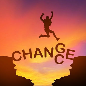Silhouette of a person jumping between cliffs over the word "CHANGE" in a vibrant sunset sky, symbolizing transformation and courage.