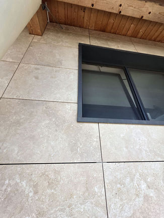 Geometric intersection between travertine slabs and window jambs on the Kerf concealed ventilated façade created by VM Group in Capalbio Scalo.