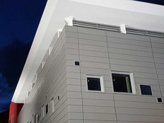 Dettaglio costruttivo dell'angolo in una facciata ventilata metallica a doghe.