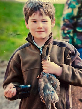 Boy proudly holding a hunted duck