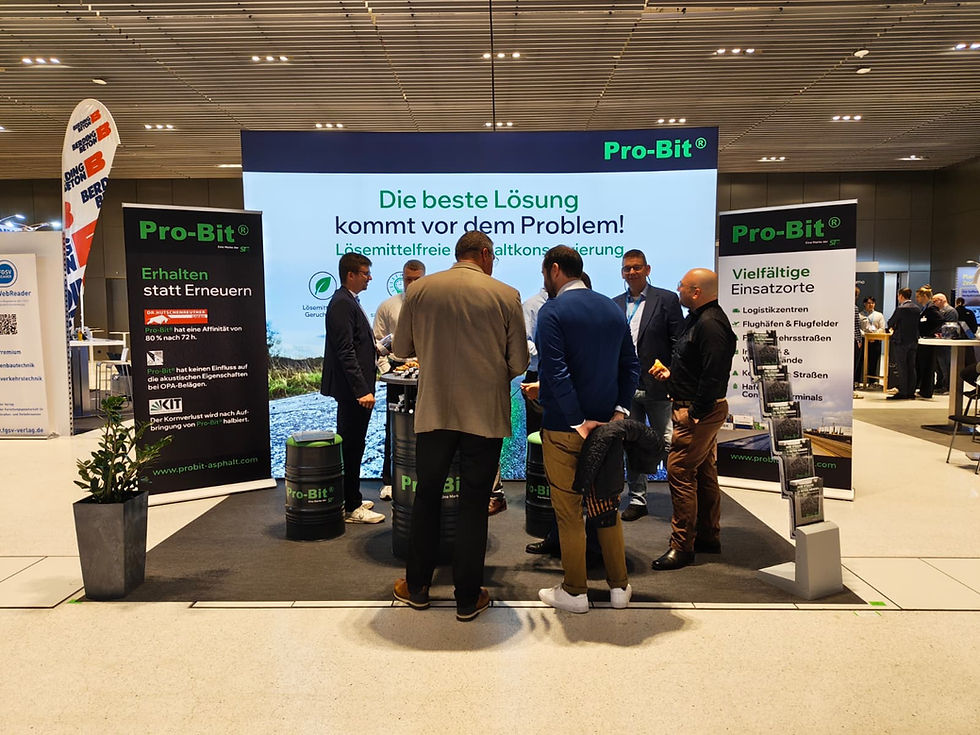 Messestand Pro-Bit: Mehrere Personen im Gespräch vor großer Leinwand mit Die beste Lösung kommt vor dem Problem!, Messehalle.