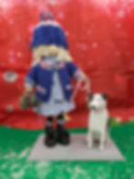 Standing Gonk with blonde curly hair, knitted bobble hat and jacket, black boots, bow lilac dress