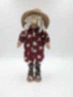 Standing Gonk with blonde hair and straw hat, wooden nose. Maroon coloured shirt dress, with dove print, flowered boots