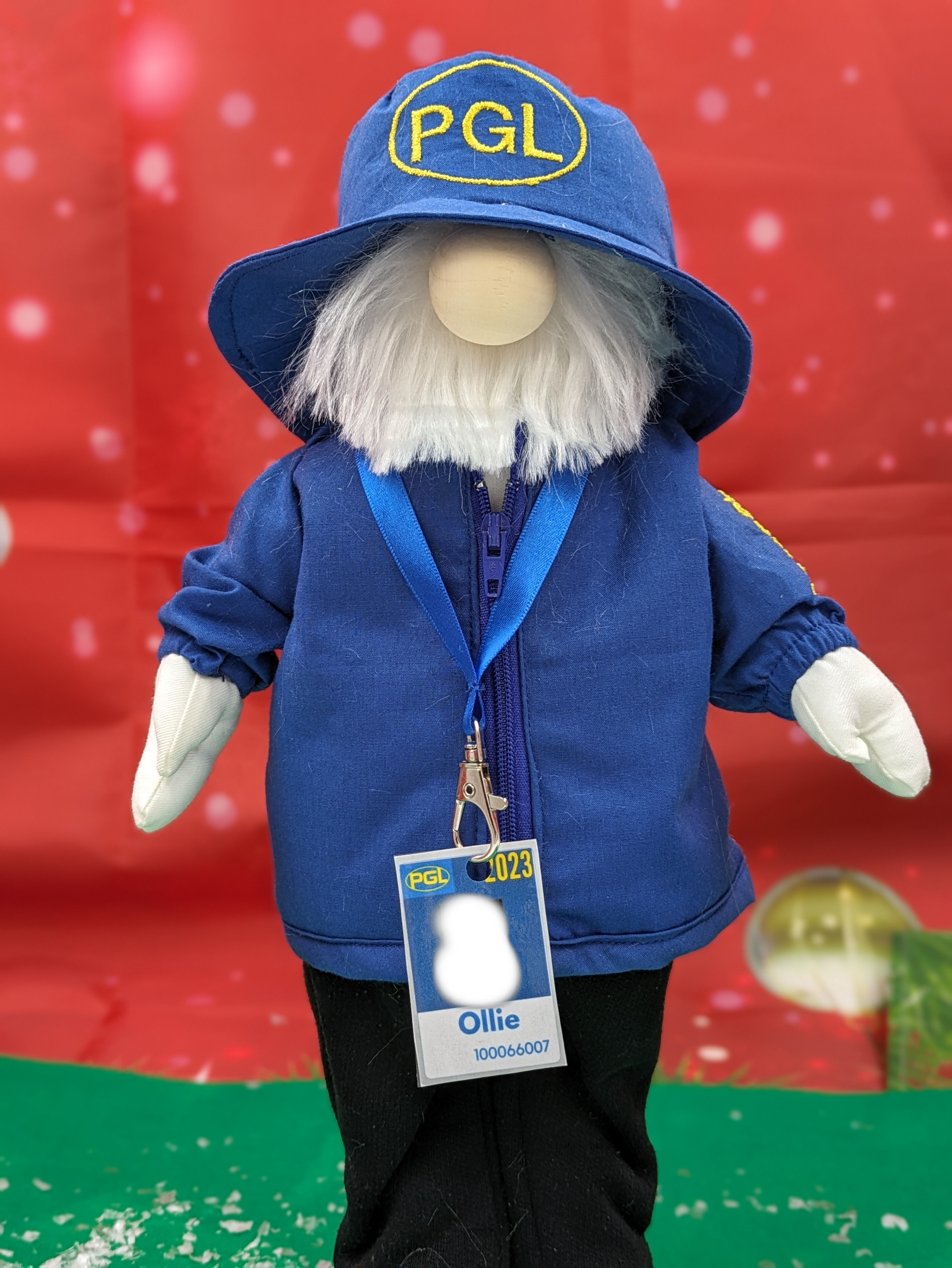 Royal blue zipped jacket, navy joggers, blue bucket hat and white beard. Lanyard