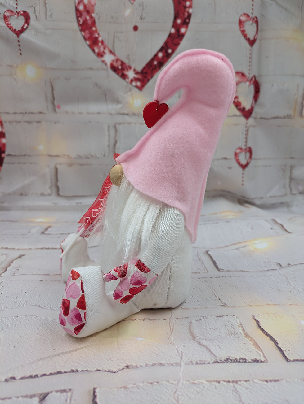 Thumbnail: White body and beard, baby pink hat with red heart at point. Holding red heart balloon saying I Love you,