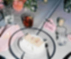 slice of cake on a wedding reception table with a drink and floral arrangements