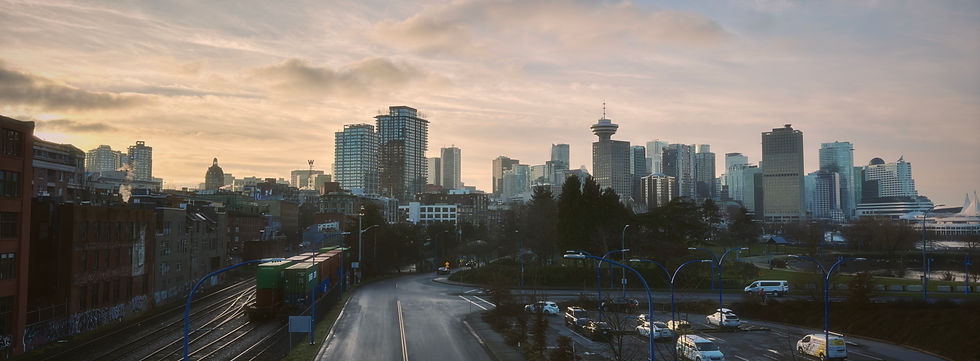 View from bridge overlooking train tracks and downtown Vancouver, wide panoramic frame.