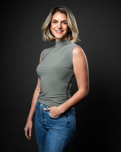 Woman in sleeveless grey top posing confidently in a studio headshot by Vancouver photographer Hampus Danielsson