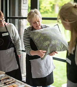 Melanie holding a pretty cow parsley stencil printed cushion and explaining to students her printing techniques.