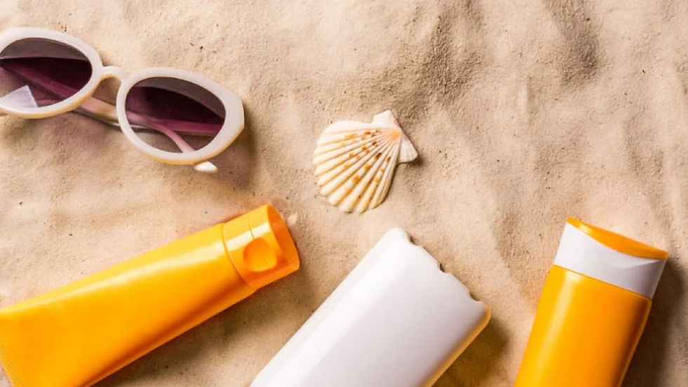 Sunscreen bottle and sunglasses resting on a sandy beach