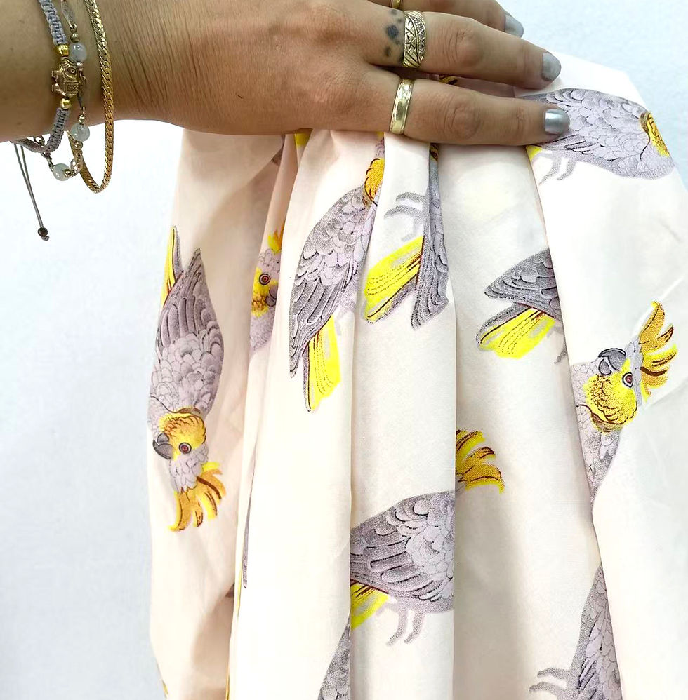Hand holding bird print fabric for fashion design & production services