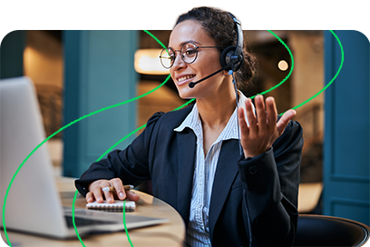 Atendimento ao cliente por telefone com colaboradora sorridente usando headset em ambiente de escritório moderno, promovendo suporte ao cliente e comunicação eficiente.