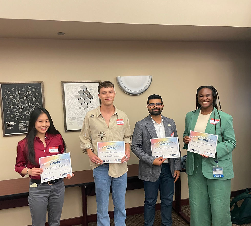 Four people posing with their certificates for winning some of the symposium awards