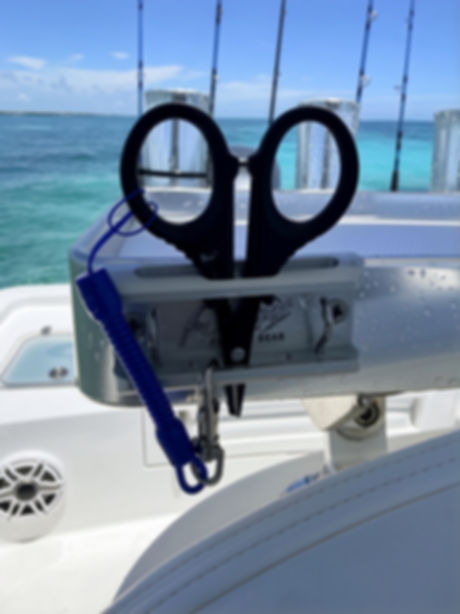 Rigit scissor plate mounted on a leaning post rigging station holding black fishing scissors