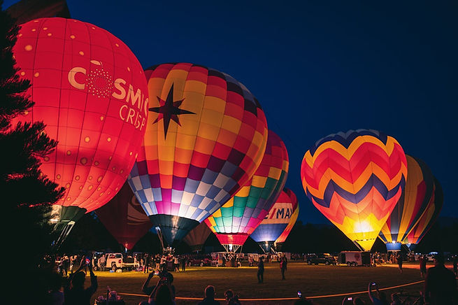 Hot air balloons on a field at night