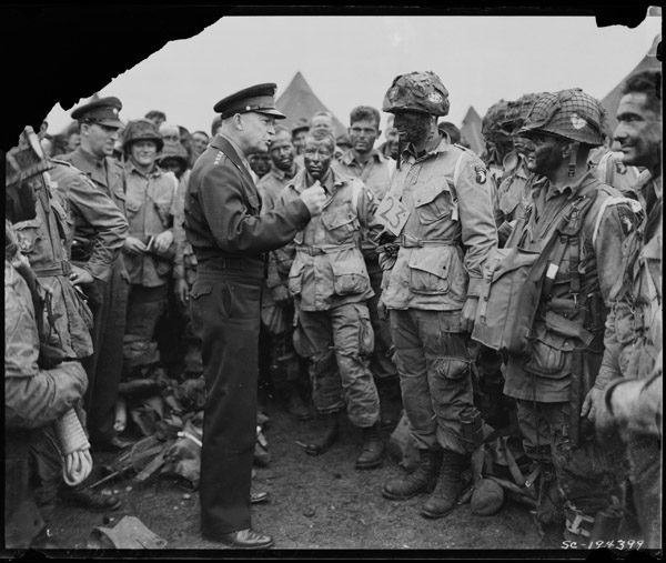 Le général Dwight D. Eisenhower donne l'ordre du jour. "Victoire complète, rien d'autre" aux parachutistes en Angleterre, juste avant de monter à bord de leurs avions pour participer au premier assaut de l'invasion du continent européen. Crédit photo : Robert F. Sargent, Garde côtière américaine / Archives nationales des États-Unis.