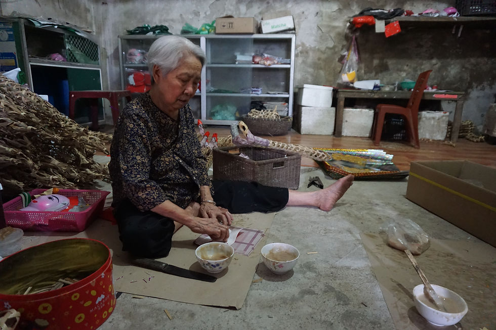A joss paper artisan applies decorative glue by hand. (Source: The Global Pulse)