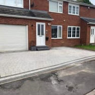 A newly installed block paved driveway in front of a modern red brick house